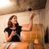 Anna Faber blickt auf ein Rotwein-Glas im Weinkeller
