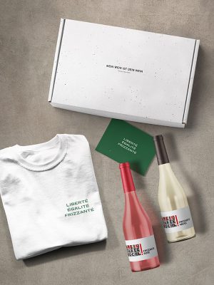 Geschenkbox mit zwei Flaschen Frizzante sowie T-Shirt und Geschenkkarte mit Aufschrift "Liberte, Egalite, Frizzante"