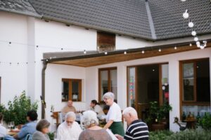 Maria Faber-Köchl bedient Gäste im Hof des Weingut Faber-Köchl