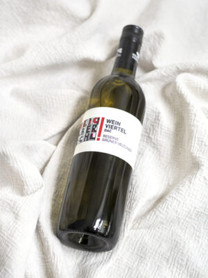 Eine Flasche Weinviertel DAC Reserve vom Weingut Faber-Köchl liegend auf einer weißen Decke