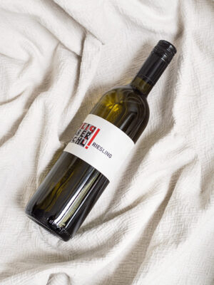 Eine Flasche Riesling vom Weingut Faber-Köchl liegend auf einer weißen Decke